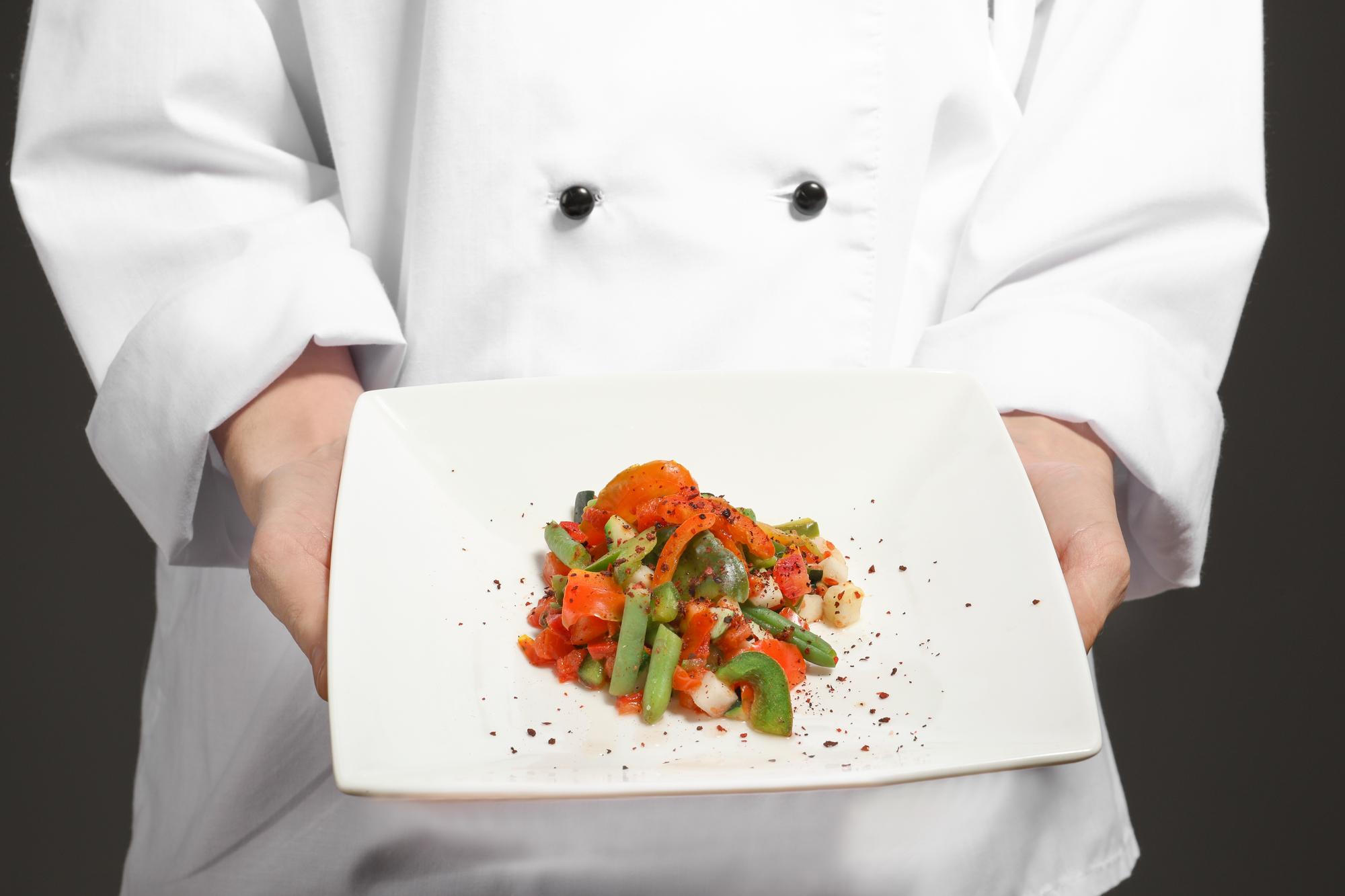 Instructor plating a modern dish in a bright kitchen